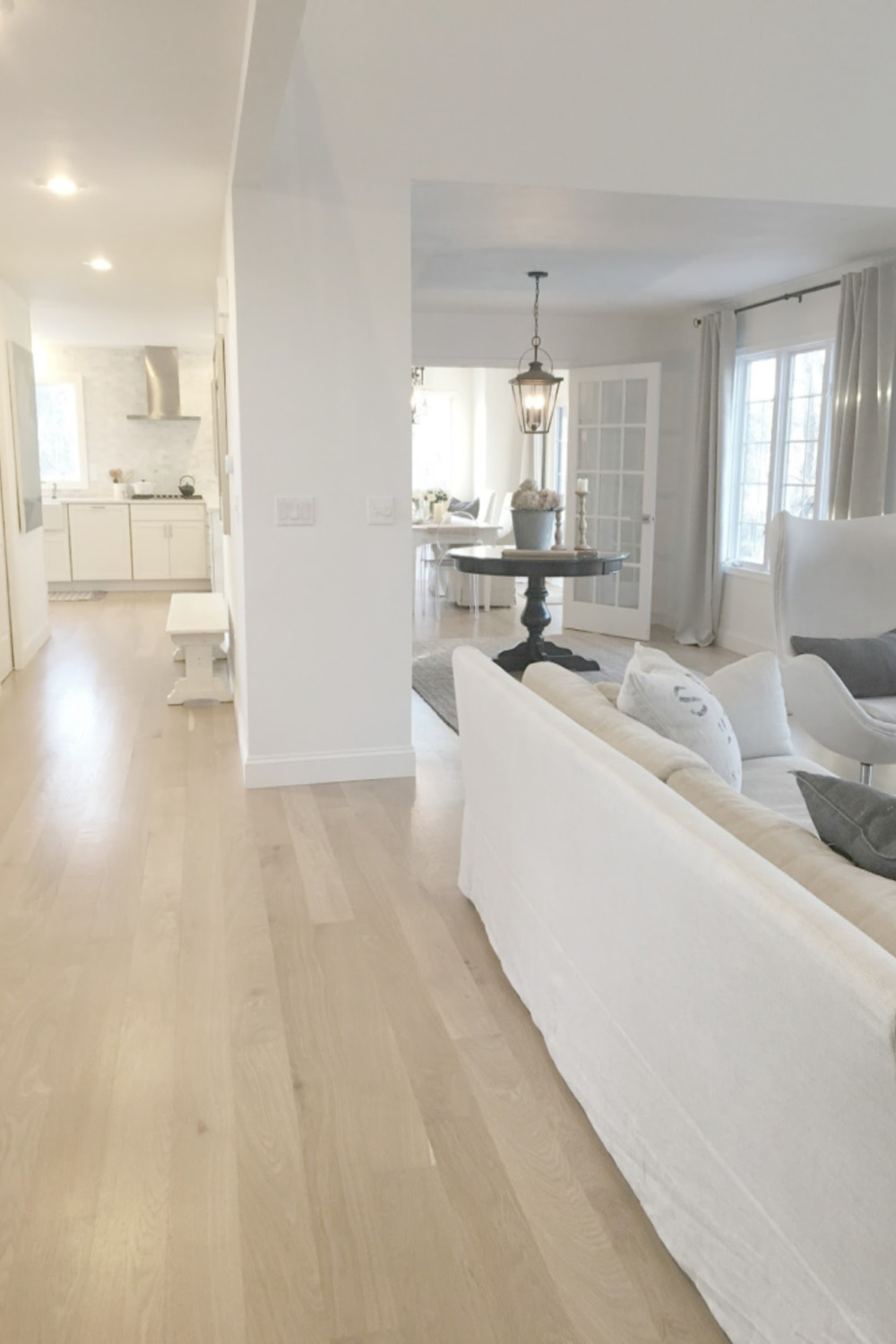 Hello Lovely Studio's white oak hardwood floors coastal grandmother living room, dining, and kitchen with Belgian linen.