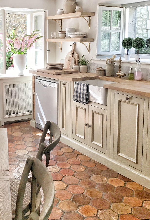 Sweet and bespoke French farmhouse kitchen by Vivi et Margot with antique terracotta hex tile floor.